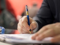 person hand writes on paper